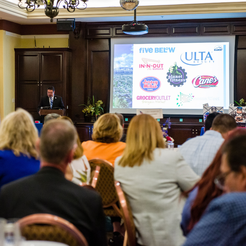 Mayor Martinez during 2019 State of the City presentation - new business logos shown on slide